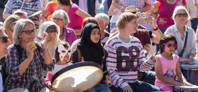 Über 100 Menschen auf dem Marktplatz in Mölln trommeln gemeinsam mit Helga Reihl und Peter Kaiser